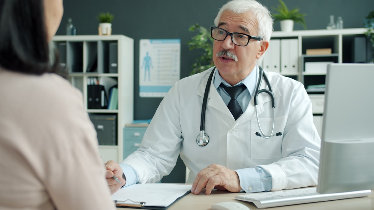 Friendly senior doctor in conversation with a patient - representing the Richmond District healthcare practice that built page-1 local discovery on neighborhood trust in under 4 months